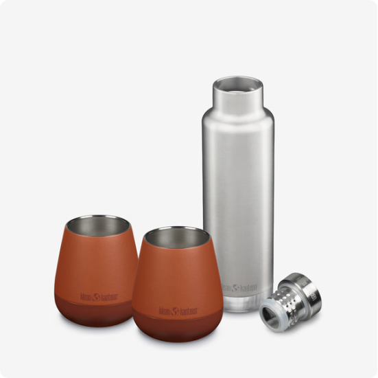 Stainless Steel thermos with 2 stainless steel tumblers which have a brown leather surface.