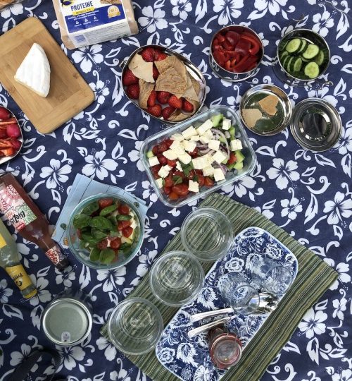 Blue and white picnic blanket with array of food