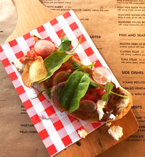 Open faced sandwich on a classic red and white picnic napkin.